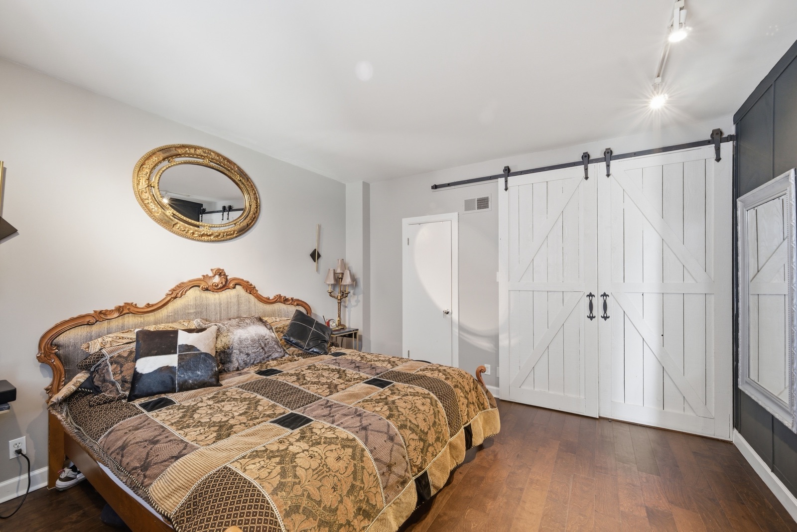 Bedroom with white barn-door closets
