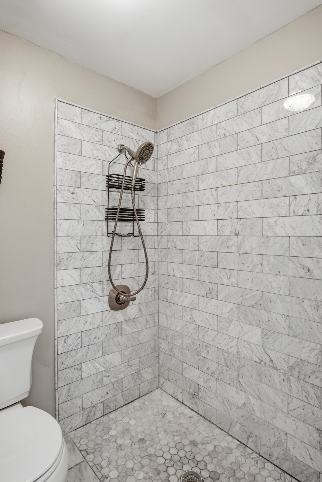 Light marble-tiled walk-in shower